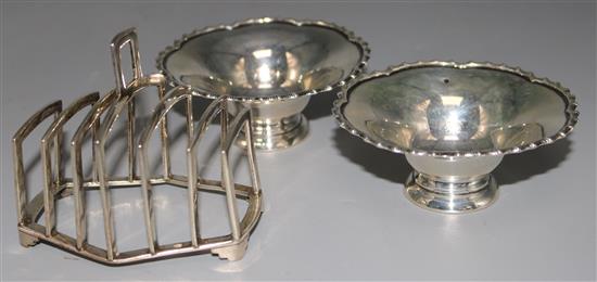 A 1930s Art Deco silver toast rack and a pair of 1920s silver bon bon dishes, 8 oz.